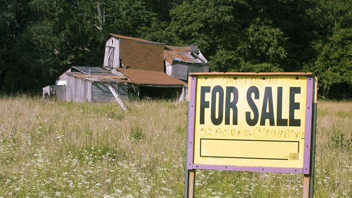 Factory farming damages livelihoods. Farm with a 'for sale' sign