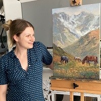 Artist Greta standing by a painting she created